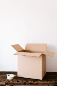 Carton box and tape with scissors on shabby table